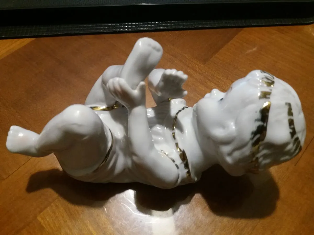 bébé couché  piano en porcelaine